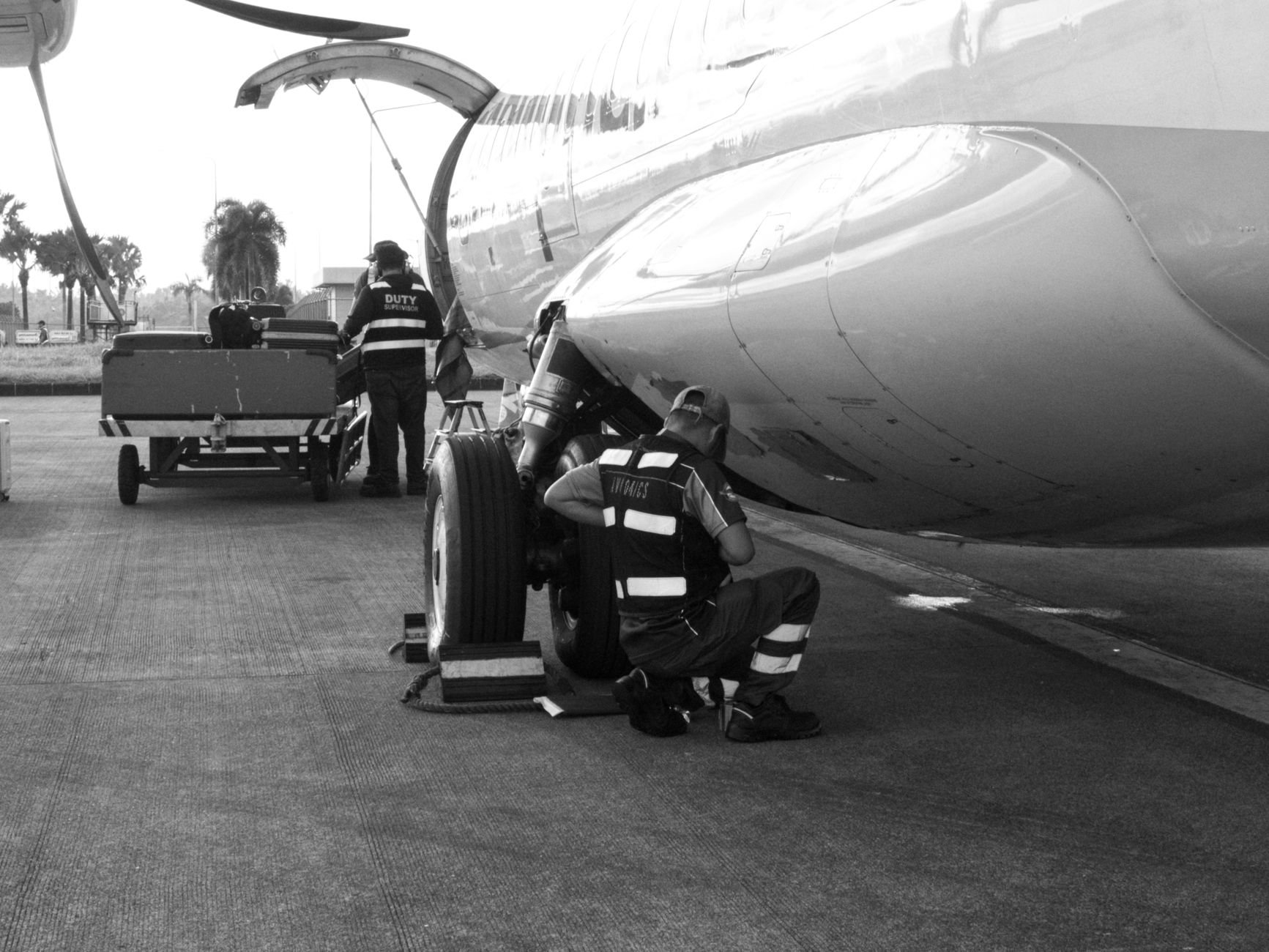 Ground crew performing aircraft maintenance on the tarmac